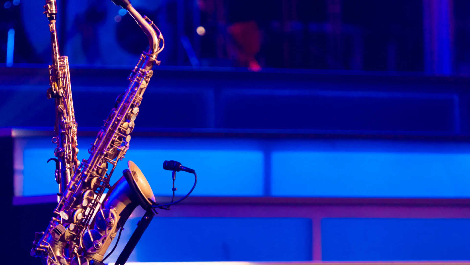 Saxophone and microphone lit in blue and violet stage light at a Will Porter live show